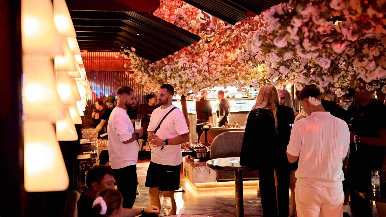 Guests mingling in a restaurant under a flowering ceiling